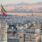 Waving,Iran,Flag,Above,Skyline,Of,Tehran,At,Sunset.